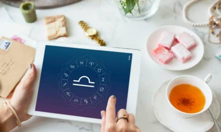 Mains tenant une tablette affichant les signes astrologiques