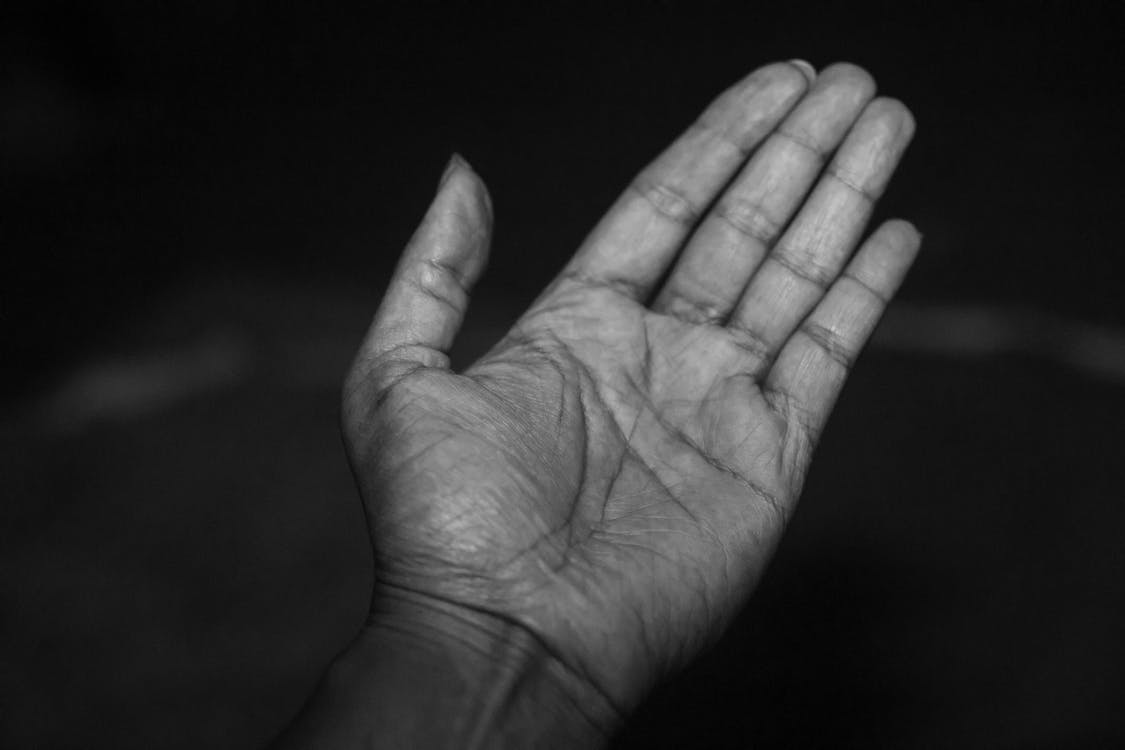 paume de main tourné vers le ciel en noir et blanc