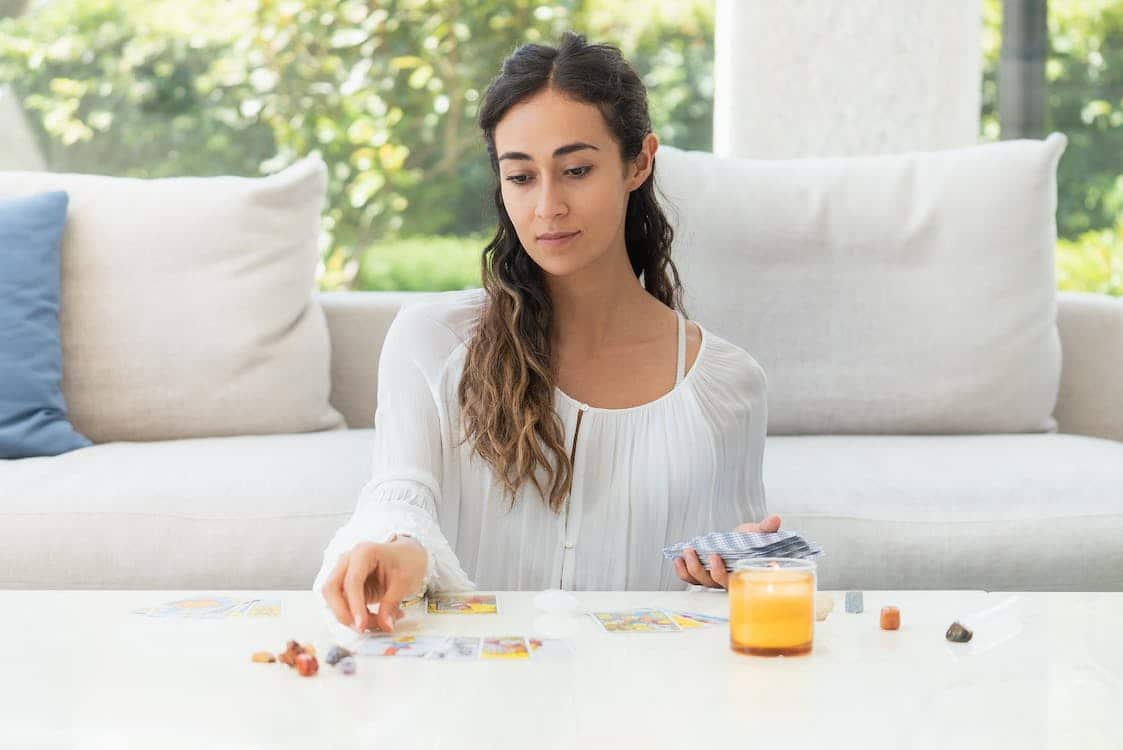 Une femme avec des cartes de tarot sur la table